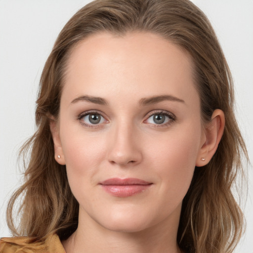 Joyful white young-adult female with long  brown hair and blue eyes