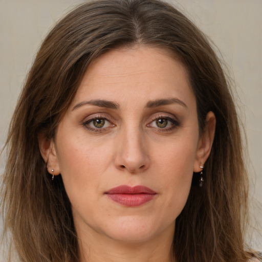 Joyful white adult female with long  brown hair and green eyes