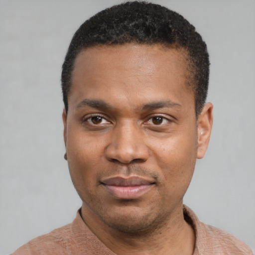 Joyful black young-adult male with short  black hair and brown eyes
