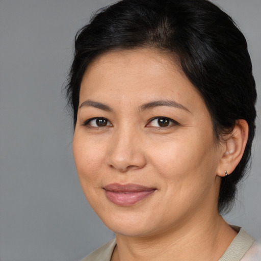 Joyful asian adult female with medium  brown hair and brown eyes