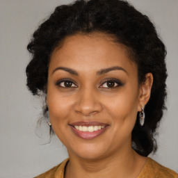 Joyful black young-adult female with long  brown hair and brown eyes