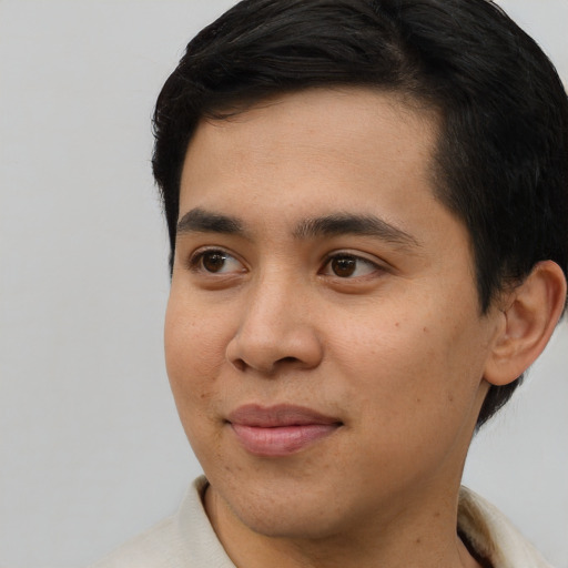 Joyful white young-adult male with short  black hair and brown eyes