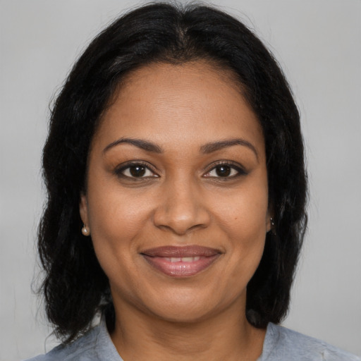 Joyful black adult female with medium  brown hair and brown eyes