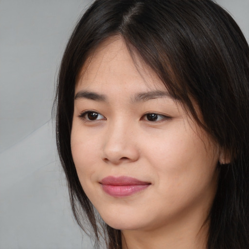 Joyful asian young-adult female with long  brown hair and brown eyes