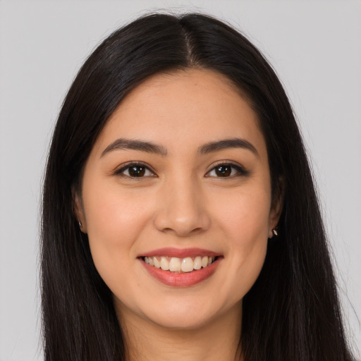 Joyful latino young-adult female with long  brown hair and brown eyes