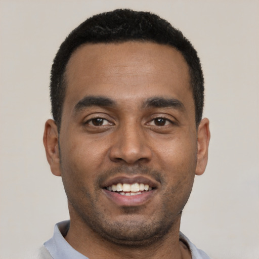Joyful black young-adult male with short  black hair and brown eyes