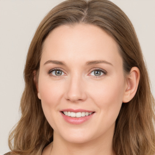 Joyful white young-adult female with long  brown hair and blue eyes