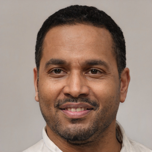 Joyful latino adult male with short  black hair and brown eyes