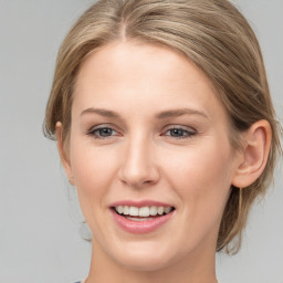 Joyful white young-adult female with medium  brown hair and grey eyes