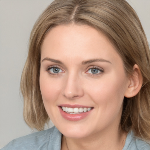 Joyful white young-adult female with medium  brown hair and blue eyes