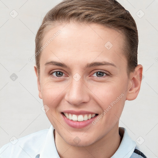 Joyful white young-adult female with short  brown hair and grey eyes