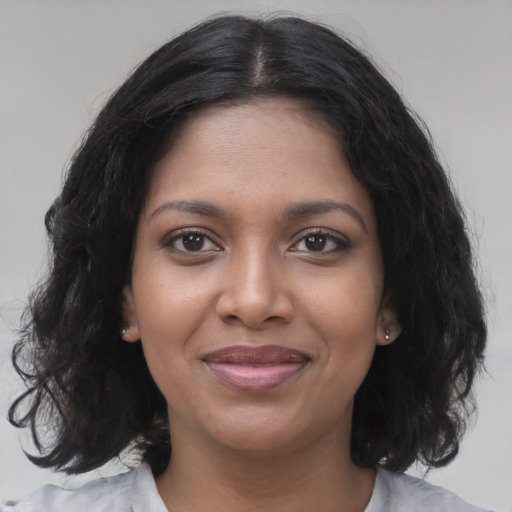 Joyful black young-adult female with medium  black hair and brown eyes