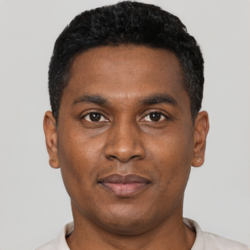 Joyful black young-adult male with short  black hair and brown eyes