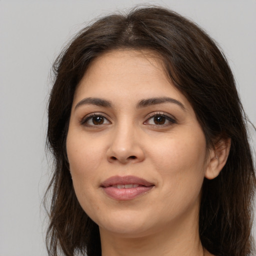 Joyful white young-adult female with long  brown hair and brown eyes