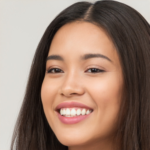 Joyful latino young-adult female with long  brown hair and brown eyes