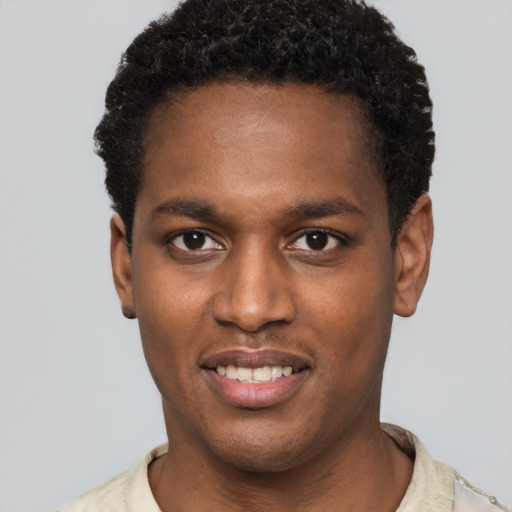 Joyful black young-adult male with short  black hair and brown eyes