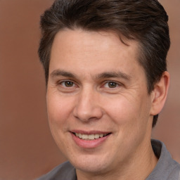 Joyful white adult male with short  brown hair and brown eyes