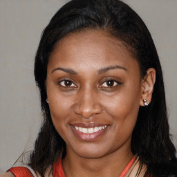 Joyful black young-adult female with long  brown hair and brown eyes