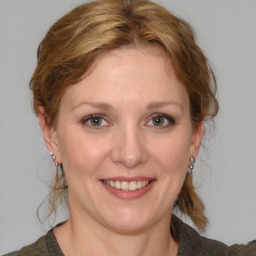 Joyful white young-adult female with medium  brown hair and blue eyes