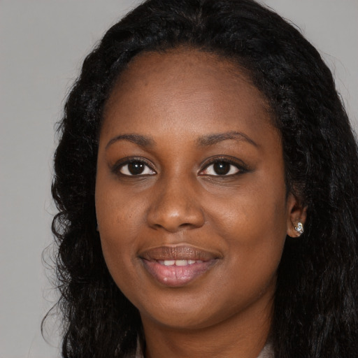 Joyful black young-adult female with long  black hair and brown eyes