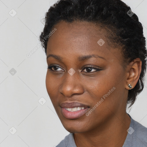 Joyful black young-adult female with short  black hair and brown eyes