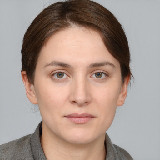 Joyful white young-adult female with medium  brown hair and grey eyes