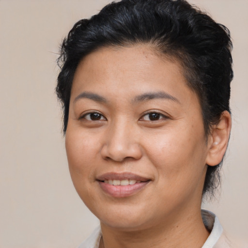 Joyful latino adult female with short  brown hair and brown eyes