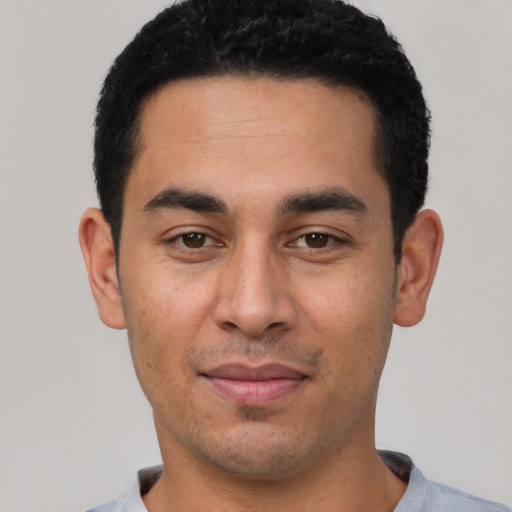 Joyful latino young-adult male with short  black hair and brown eyes