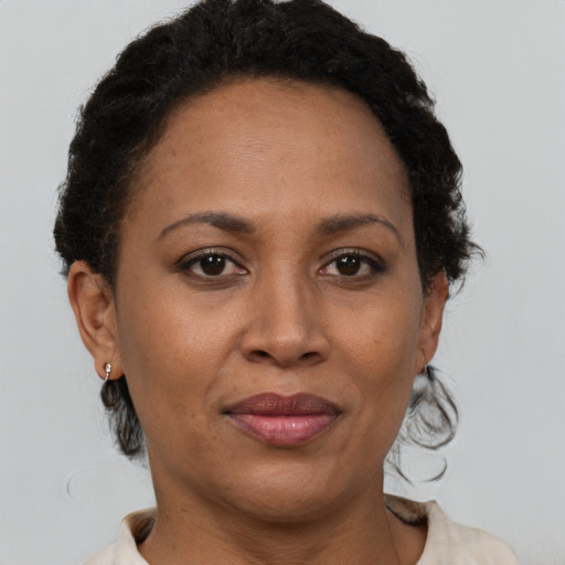 Joyful black adult female with short  brown hair and brown eyes