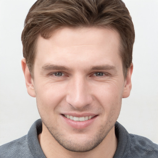 Joyful white young-adult male with short  brown hair and grey eyes