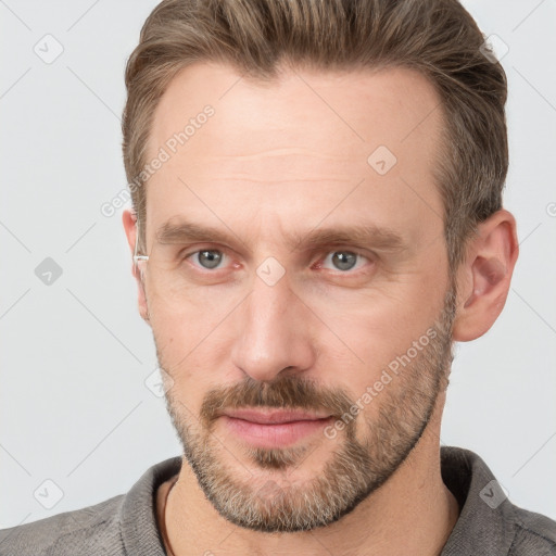 Joyful white adult male with short  brown hair and grey eyes