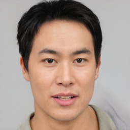 Joyful asian young-adult male with short  brown hair and brown eyes