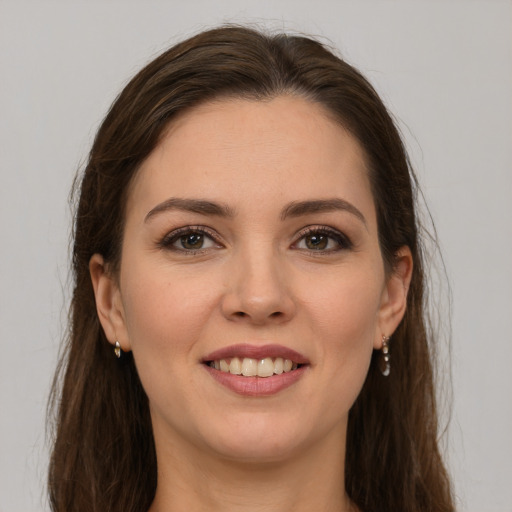 Joyful white young-adult female with long  brown hair and brown eyes