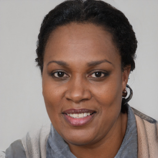 Joyful black adult female with short  black hair and brown eyes