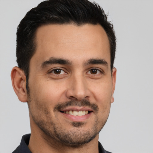 Joyful white young-adult male with short  black hair and brown eyes