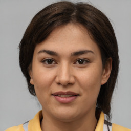 Joyful latino young-adult female with medium  brown hair and brown eyes