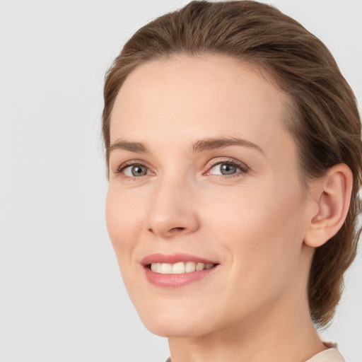 Joyful white young-adult female with medium  brown hair and grey eyes