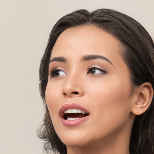 Joyful white young-adult female with long  black hair and brown eyes