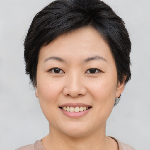 Joyful asian young-adult female with short  brown hair and brown eyes