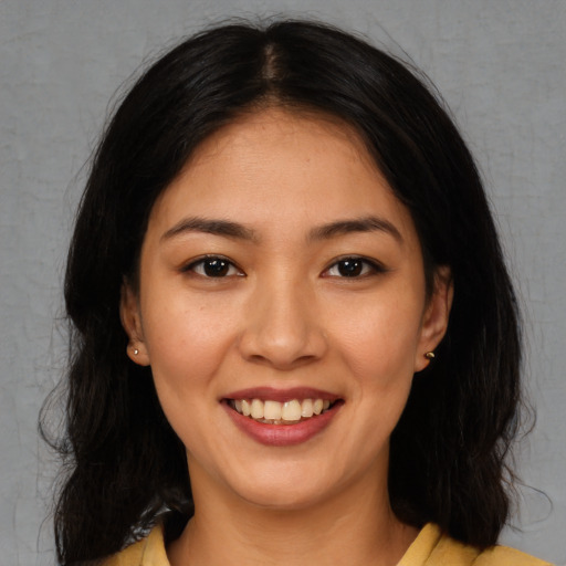 Joyful latino young-adult female with long  brown hair and brown eyes
