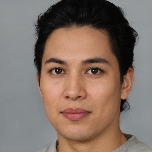 Joyful latino young-adult male with short  black hair and brown eyes