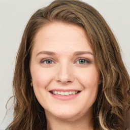 Joyful white young-adult female with long  brown hair and green eyes