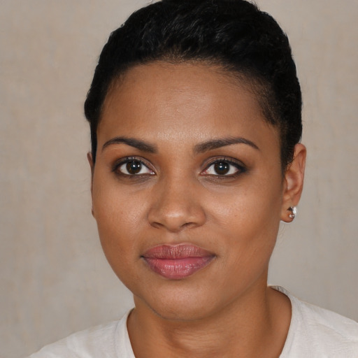 Joyful black young-adult female with short  black hair and brown eyes