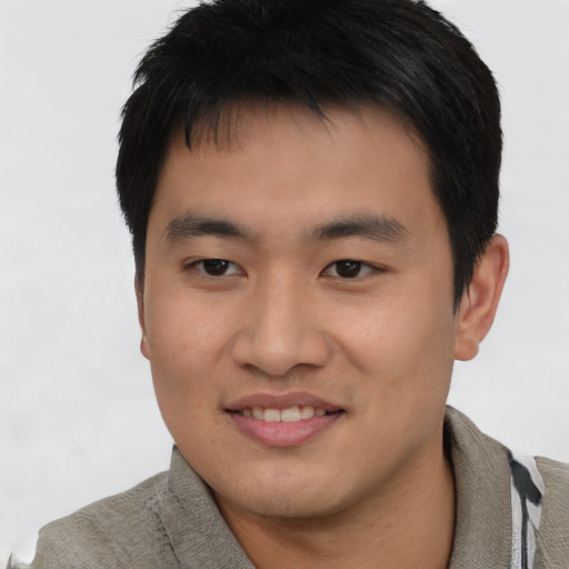 Joyful asian young-adult male with short  black hair and brown eyes