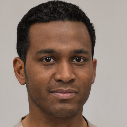 Joyful black young-adult male with short  black hair and brown eyes