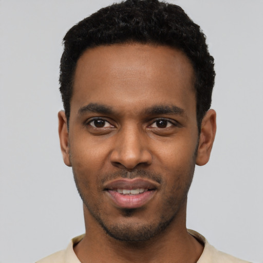 Joyful black young-adult male with short  black hair and brown eyes