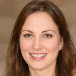 Joyful white young-adult female with long  brown hair and green eyes