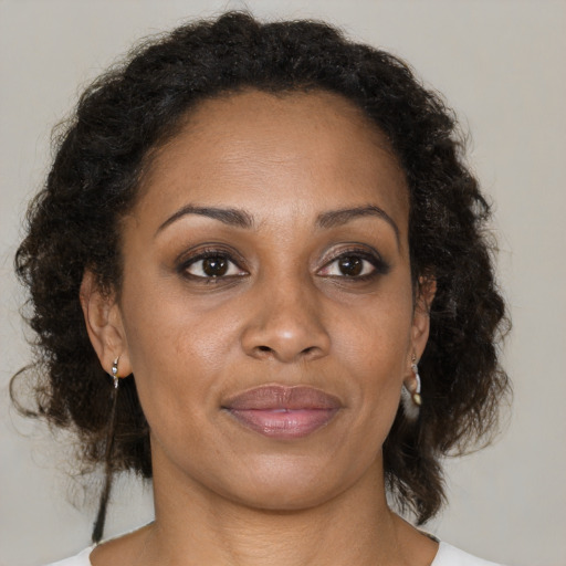 Joyful black adult female with medium  brown hair and brown eyes