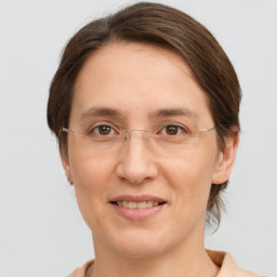 Joyful white adult female with medium  brown hair and grey eyes