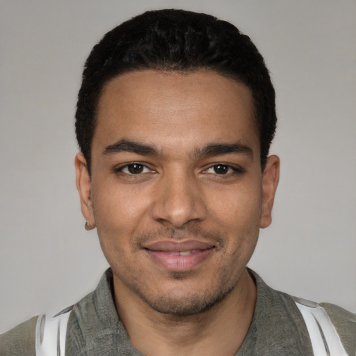 Joyful latino young-adult male with short  black hair and brown eyes